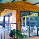 Wood walls with sliding glass doors and blue awnings