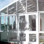 White awnings and glass walls installation on glasshouse / conservatory